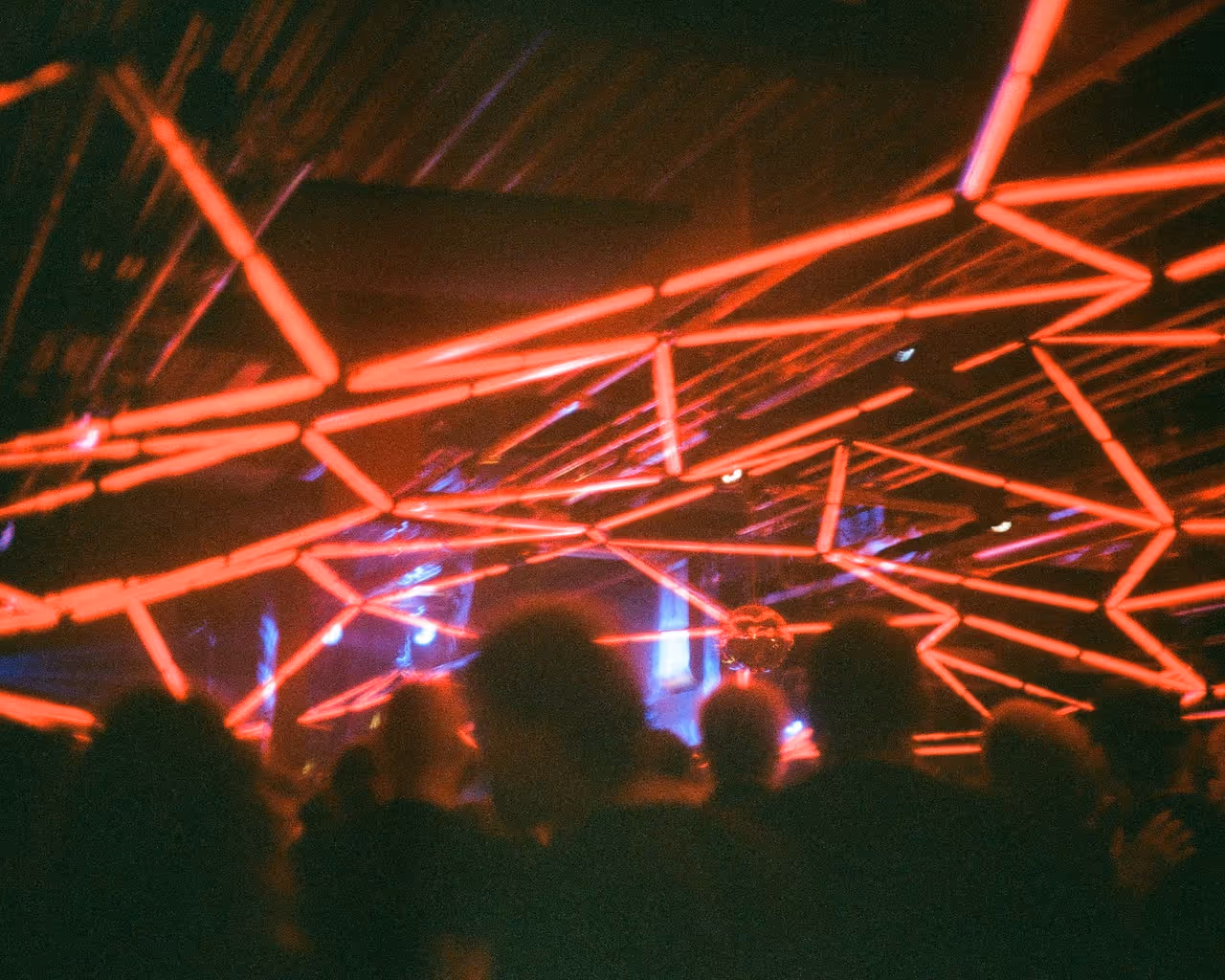 Neon-lit crowd entering venue